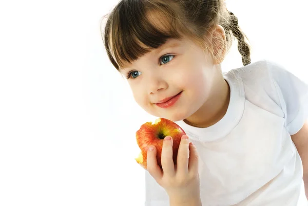 Маленькая девочка ест яблоко — стоковое фото