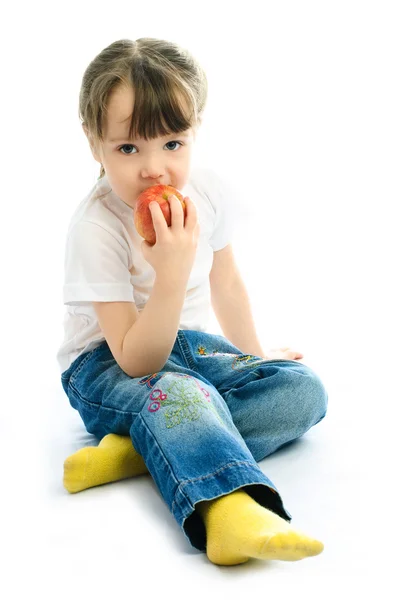Lille pige spiser et æble - Stock-foto