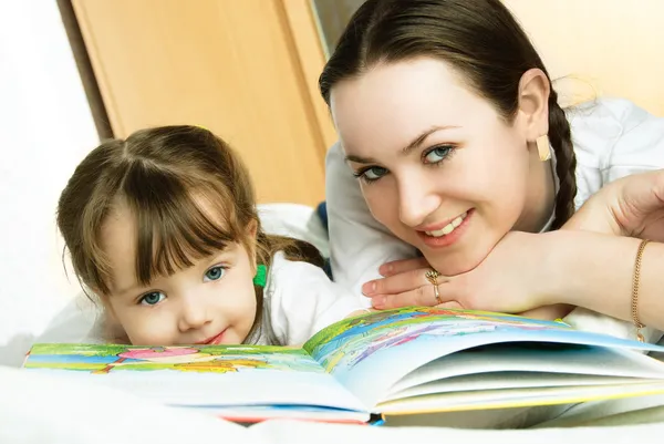 Anne ve kızı kitap okuyorlar. — Stok fotoğraf