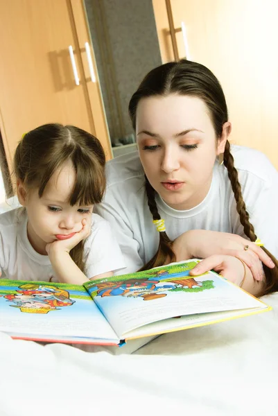 Madre e hija leyendo un libro — Foto de Stock