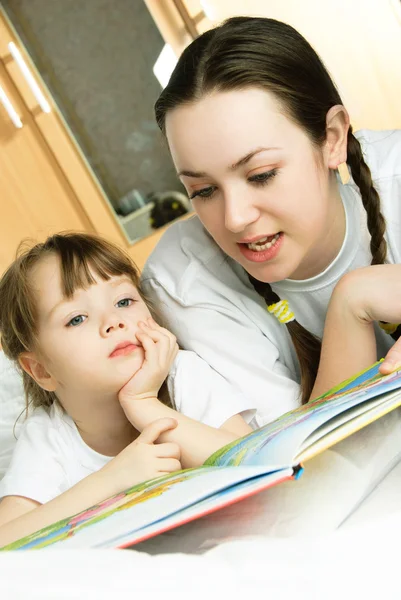 Mãe e sua filha lendo um livro — Fotografia de Stock