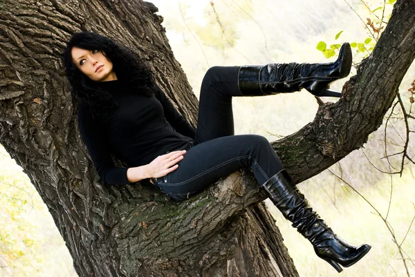 Menina melancólica sentada na árvore — Fotografia de Stock