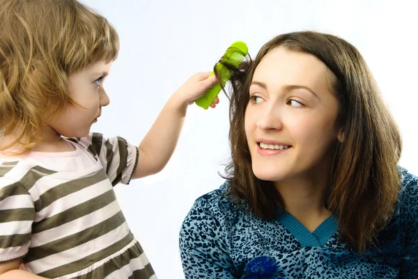 Girl brushing her mothers hair — Stock Photo, Image