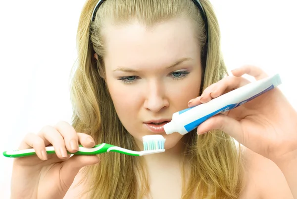 Frau trägt Zahnpasta auf — Stockfoto