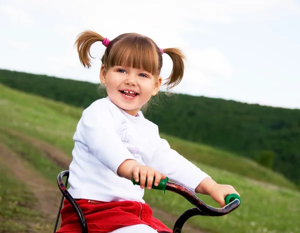 Симпатичная двухлетняя девочка верхом на бисикле — стоковое фото