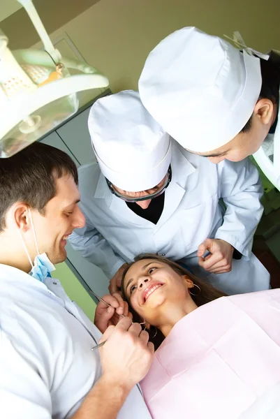 Tres dentistas y un paciente —  Fotos de Stock