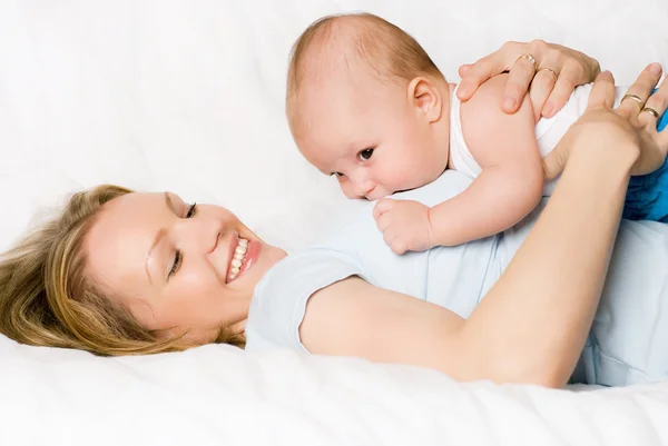 Mãe feliz com seu filho na cama — Fotografia de Stock