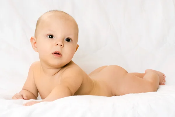 Симпатичный четырехмесячный ребенок на белом диване — стоковое фото