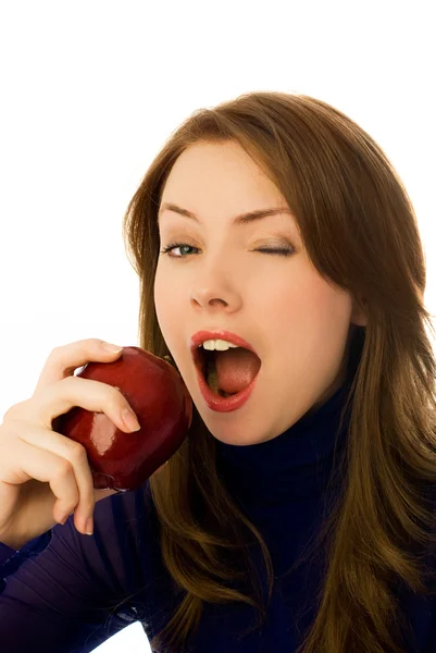 Beautiful woman eats and apple and winks — Zdjęcie stockowe
