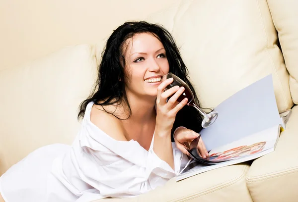 Красива жінка розслабляється на дивані з коктейлем — стокове фото