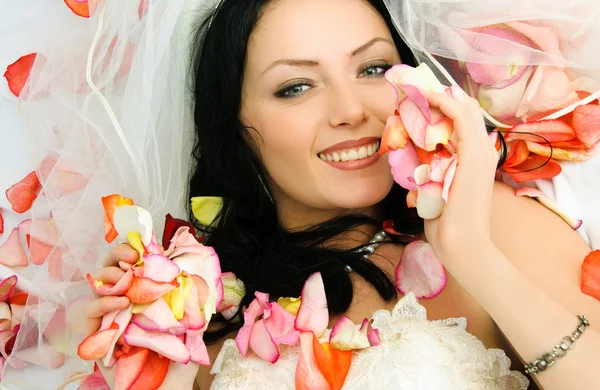 Brunette noiva na cama coberta com rosa saav — Fotografia de Stock