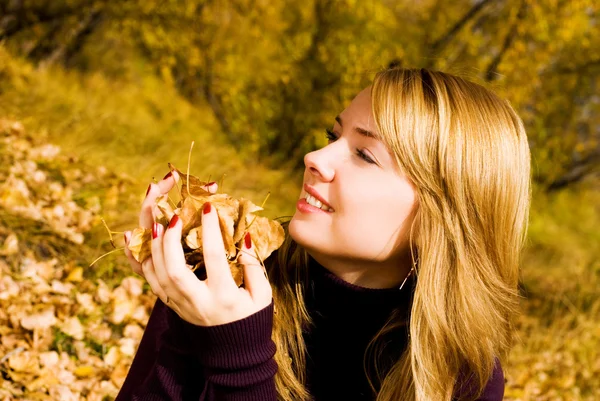 Pretty girl with yellow leaves in the park — Stock Photo, Image