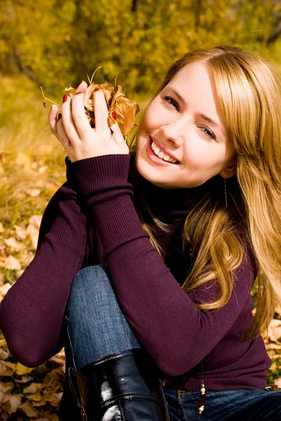 Ładna dziewczyna z żółtymi liśćmi w jej ręce — Zdjęcie stockowe