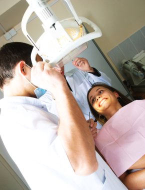 Dentist and his assistant examine a patient clipart