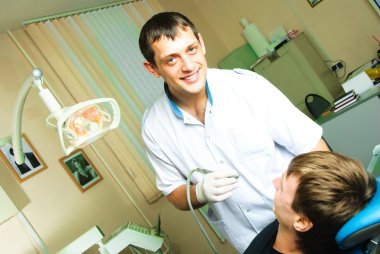 Dentist curing the patient's teeth clipart