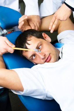 Unhappy man sitting in the dentist's chair clipart