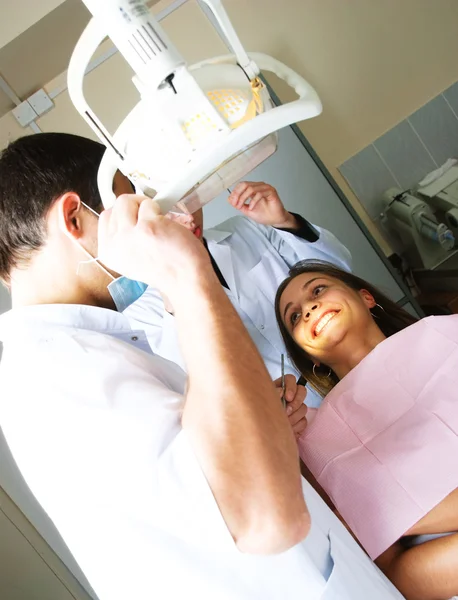 Οδοντίατρος και τον βοηθό του να εξετάσει ασθενής — Φωτογραφία Αρχείου
