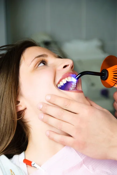 Dentist curing the patient's teeth with ultravio — Stock Photo, Image