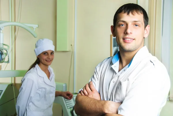 Junger erfolgreicher Zahnarzt mit seiner Assistentin — Stockfoto