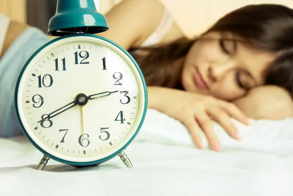 Mulher adormecida bonita com um despertador — Fotografia de Stock