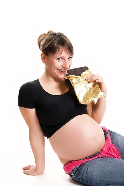 Çikolata yiyen hamile kadın. — Stok fotoğraf