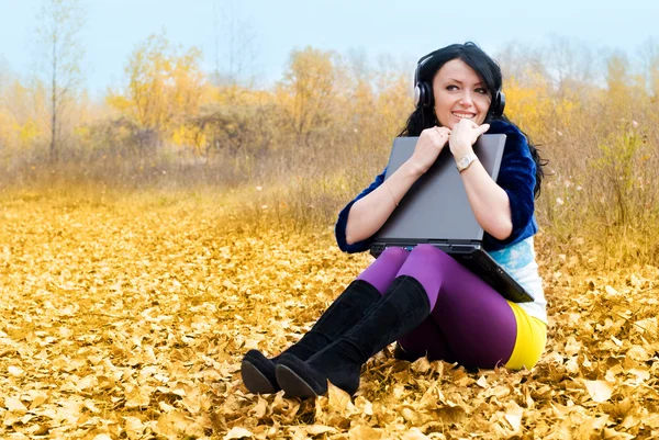 Красивая девушка с ноутбуком на открытом воздухе — стоковое фото