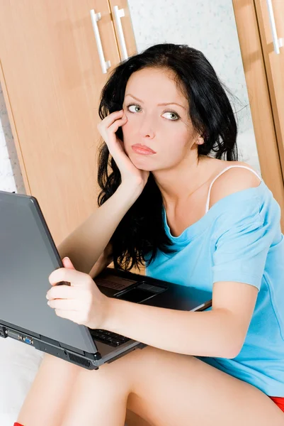 Chica aburrida con un ordenador portátil —  Fotos de Stock