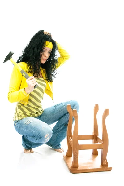 Puzzled woman repairs a chair — Stock Photo, Image