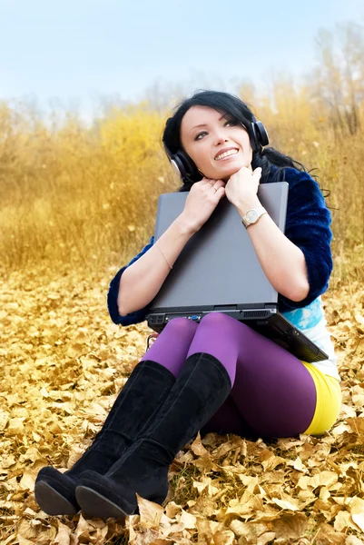 Красива дівчина з ноутбуком на відкритому повітрі — стокове фото