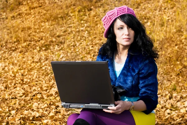Drömmande flicka med en laptop utomhus — Stockfoto