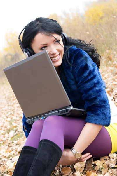 Щаслива дівчина з ноутбуком на вулиці — стокове фото