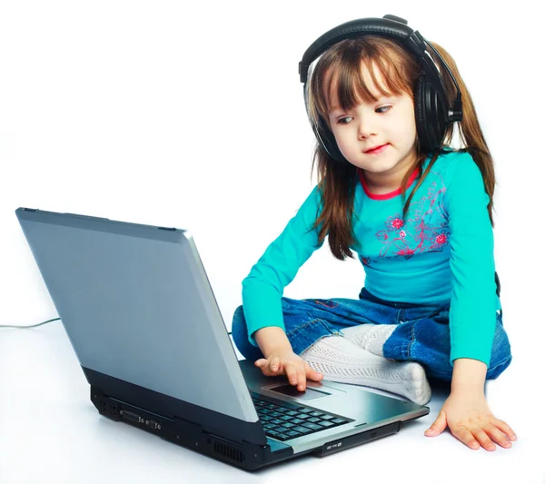 Klein meisje met een laptop — Stockfoto