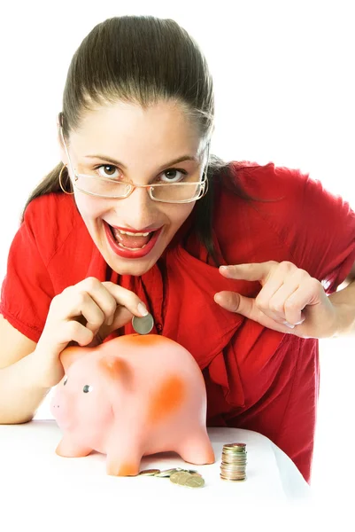Opgewonden vrouw een munt ingebruikneming haar piggy bank — Stockfoto