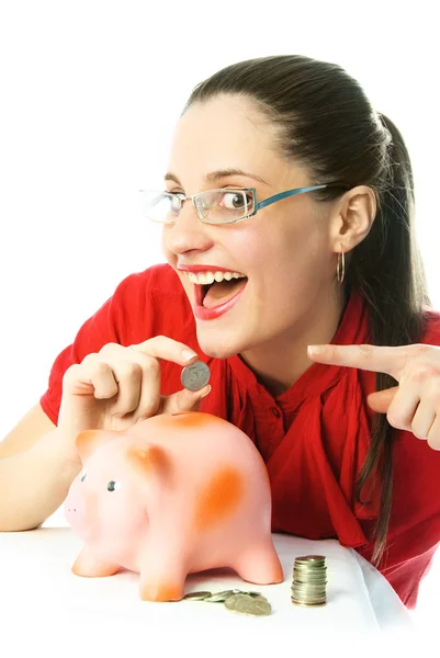 Aufgeregte Frau steckt eine Münze in ihr Sparschwein — Stockfoto