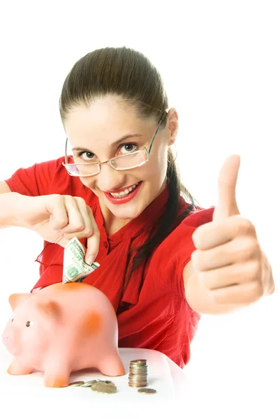 Young woman putting money into the piggy bank — Stockfoto