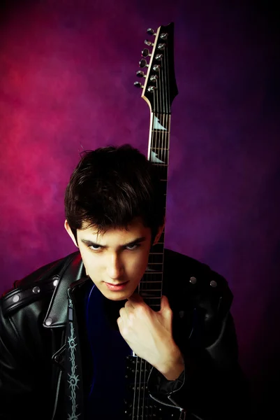 Düsterer junger Mann mit Gitarre — Stockfoto
