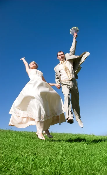 Happy jumping bride and groom on the hill — Stock Photo, Image