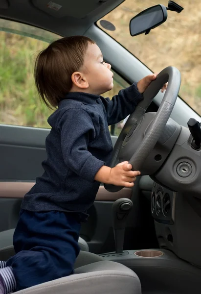 Ένα μικρό αγόρι οδηγεί ένα αυτοκίνητο. — Φωτογραφία Αρχείου