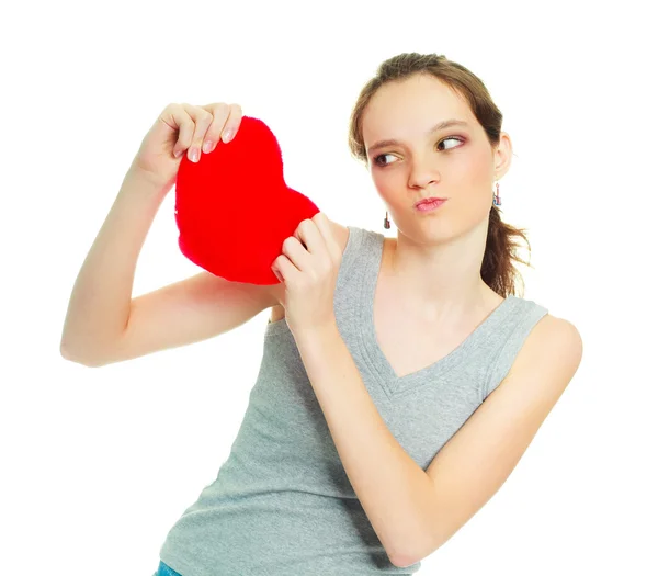 Menina rasgando um travesseiro em forma de coração — Fotografia de Stock