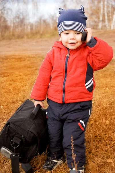 Viajante engraçado com um saco e um celular-phon — Fotografia de Stock