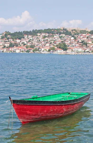 Boat with coast town in background — Stock Photo, Image