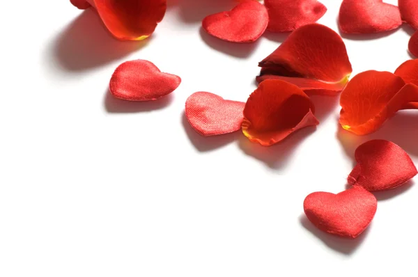 Rosenblätter und Herzen auf weißem Hintergrund — Stockfoto