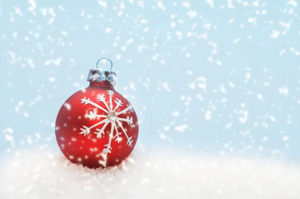 Bola roja de Navidad y nevando — Foto de Stock