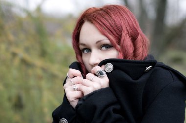 Redhead flirty goth girl in a black coat clipart