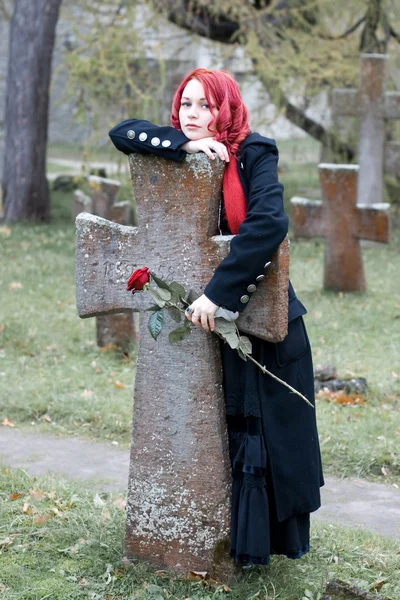 Gothic κορίτσι με ένα τριαντάφυλλο σε ένα νεκροταφείο — Φωτογραφία Αρχείου