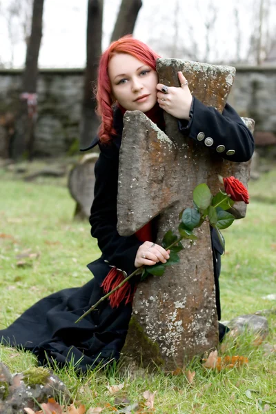 Gothic κορίτσι με ένα τριαντάφυλλο σε ένα νεκροταφείο — Φωτογραφία Αρχείου