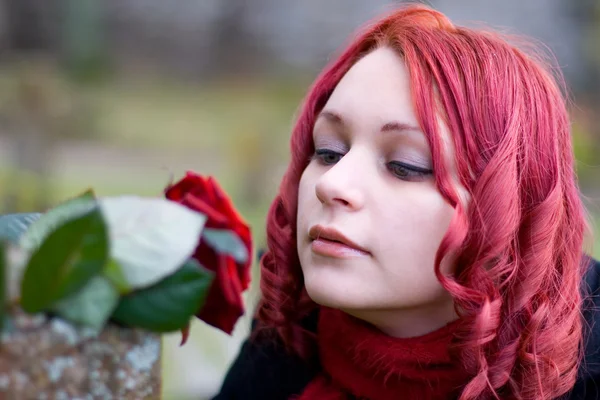 Närbild av rödhårig tjej med en ros — Stockfoto
