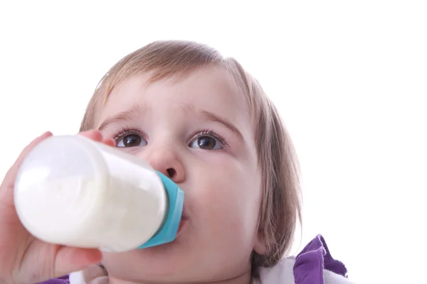 Ett barn med en flaska mjölk — Stockfoto