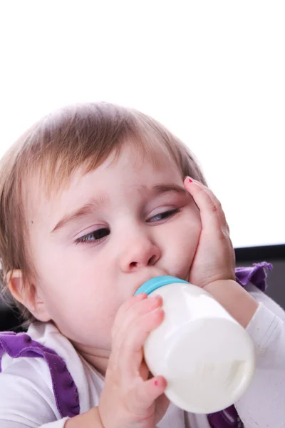 En baby med en flaske melk – stockfoto