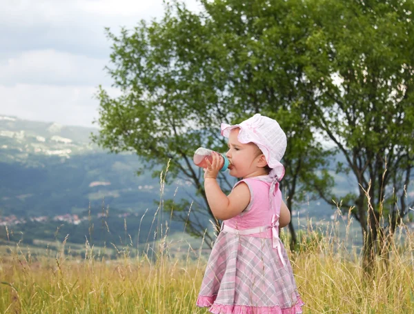 草の上に瓶を持つ赤ちゃん — ストック写真